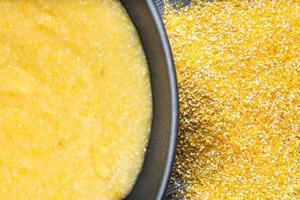 cooked maize porridge in gray bowl and cornmeal photo