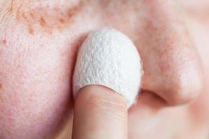 woman cleans skin with natural silkworm cocoon photo