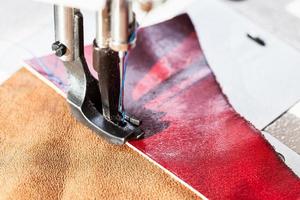 sewing machine sews leather pieces photo