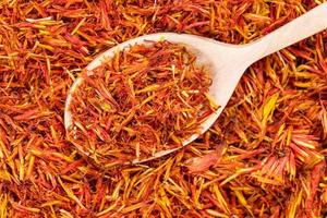 spoon with dried safflower petals on dried flowers photo