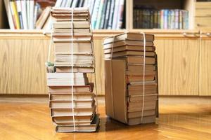 two stacks of books tied with rope near bookcase photo