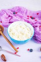 Cottage cheese with honey and berries on pink background. Light vegetarian breakfast