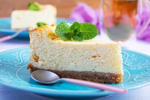 Sliced cheesecake. Delicious sweet cheesecake with mint tea on wooden background photo