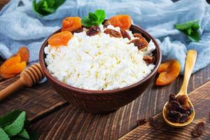 Healthy breakfast cottage cheese with raisins, dried apricots, almond, cashew and mint photo