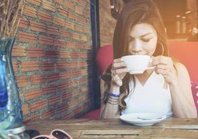 dama bebiendo café en una cafetería vintage foto