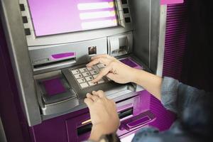 People waiting to get money from automated teller machine - people withdrawn money from ATM concept photo