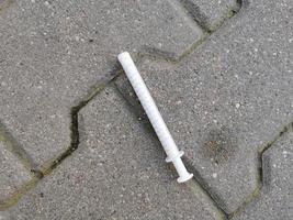 The used syringe is lying on the road photo