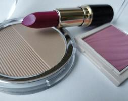 Cosmetic set with red lipstick, powder and blush photo