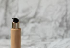 Beige foundation cream for the face on a light background photo