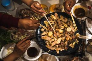 People hands using chopstick with barbecue grill at a party. Food, people and family time concept. photo