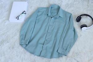 Fashion flat lay of long-sleeve shirt with headphone and glasses photo