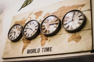 Four timezone wall clocks showing different time in the world with vintage design. photo