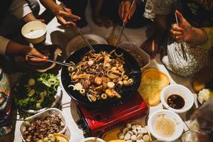 People hands using chopstick with barbecue grill at a party. Food, people and family time concept. photo