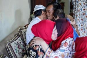 lebaran regreso a casa en su ciudad natal se saludan disculpándose durante el eid. la familia se abraza, los padres con sus hijos. foto