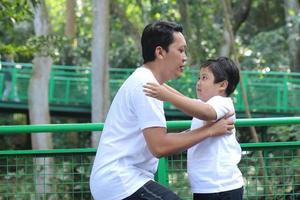 feliz padre e hijo asiáticos jugando y divirtiéndose al aire libre. concepto de familia, infancia y paternidad foto