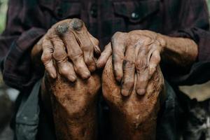 primer plano de las manos arrugadas masculinas, el anciano lleva puesto foto