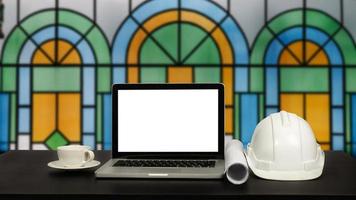 Front view of laptop computer and office construction on table in office blurred background.Architect concept. photo