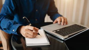 businessman hand working with new modern computer and writing on the notepad strategy diagram as concept photo