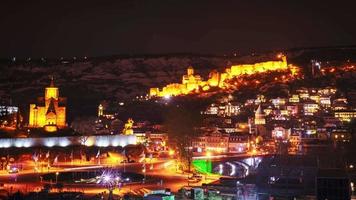 dynamische snelle beweging time-lapse van de bezienswaardigheden van de oude stad van Georgië met passerende auto's in de winternacht. sightseeing reizen Georgië banner video