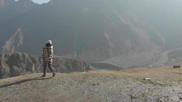 la mujer caucásica se para emocionada en el punto de vista en las montañas, hacer turismo y viajar en la naturaleza otoñal al aire libre video