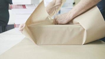 Close up man's hands packing boxes of sellotape in printing industry