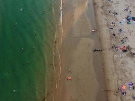 Frente a la playa con vistas al mar en ángulo alto con gente en la ciudad de Bournemouth, Inglaterra, Reino Unido, imágenes aéreas del océano británico foto