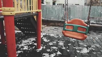 Baby swings swinging with no child in kids playground. Concept of grief and baby loss video