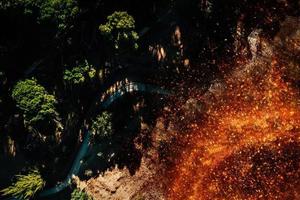 Top down aerial view of forest fire in shrubs and trees next to a path in the forest photo