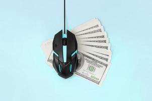 Black computer mouse on many hundred dollar bills photo