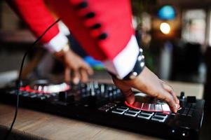 Hands of fashion african american man model DJ at red suit with dj controller. photo