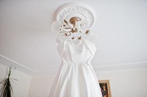 Wedding dress hanging ceiling. Bride day. photo