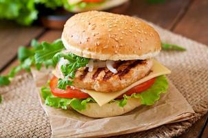 Sandwich with chicken burger, tomatoes, cheese and lettuce photo