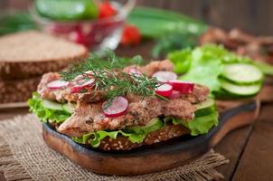 Sandwich with meat, vegetables and slices of rye bread photo