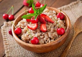 Oatmeal porridge with berries in a white bowl photo