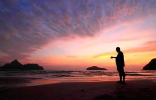 young man and sunset on sea photo