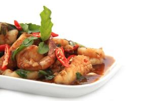 Spicy seafood fried served on white dish photo