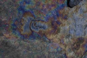 petróleo crudo en agua de mar y reflejo del arco iris foto