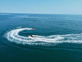 High Angle Footage and Aerial view of Ocean with High Speed Boats, People are having fun and enjoying hottest weather at Bournemouth Beach Sea Front of England UK. photo