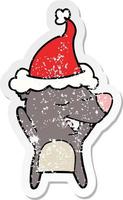 distressed sticker cartoon of a bear wearing santa hat vector