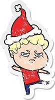 distressed sticker cartoon of a angry man wearing santa hat vector