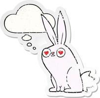 cartoon bunny rabbit in love and thought bubble as a distressed worn sticker vector