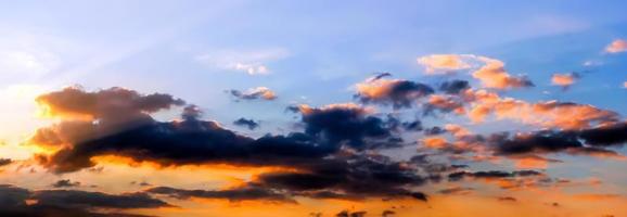 Beautiful high resolution panorama of orange and red sunset clouds in the evening sky photo