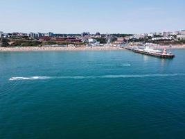 imágenes de alto ángulo y vista aérea del océano con botes de alta velocidad, la gente se divierte y disfruta del clima más cálido en la playa de bournemouth, frente al mar en inglaterra, reino unido. foto