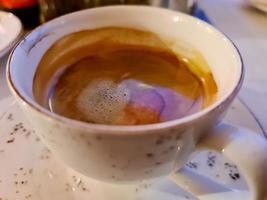 Selectuve focus view at a coffee surface in a white cup photo
