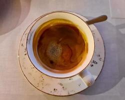 Selectuve focus view at a coffee surface in a white cup photo