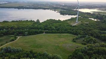 High Angle Aerial View footage over Windmill Wind Turbine at Stewartby Lake of England at Sunrise photo