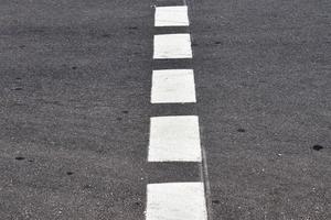 Different signs and marking painted on the ashpalt of streets and roads. photo