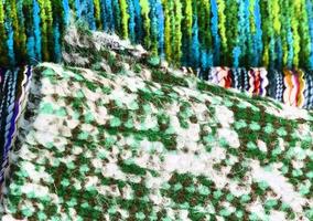 Detailed close up view on samples of cloth and fabrics in different colors found at a fabrics market photo