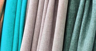 Detailed close up view on samples of cloth and fabrics in different colors found at a fabrics market photo