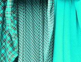 Detailed close up view on samples of cloth and fabrics in different colors found at a fabrics market photo